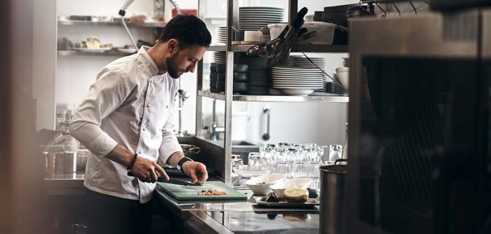 chef working in commercial kitchen to illustrate waste disposal and food safety 